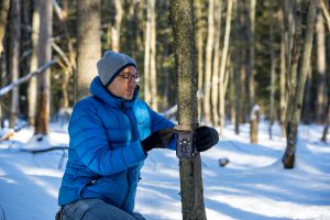 alessio mortelliti setting up trail cam on a tree outside in the snow