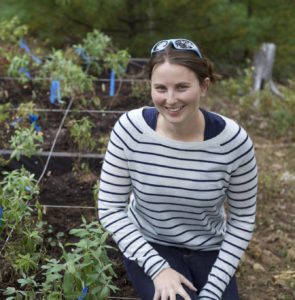 Caitlin in striped shirt next to experimental garden