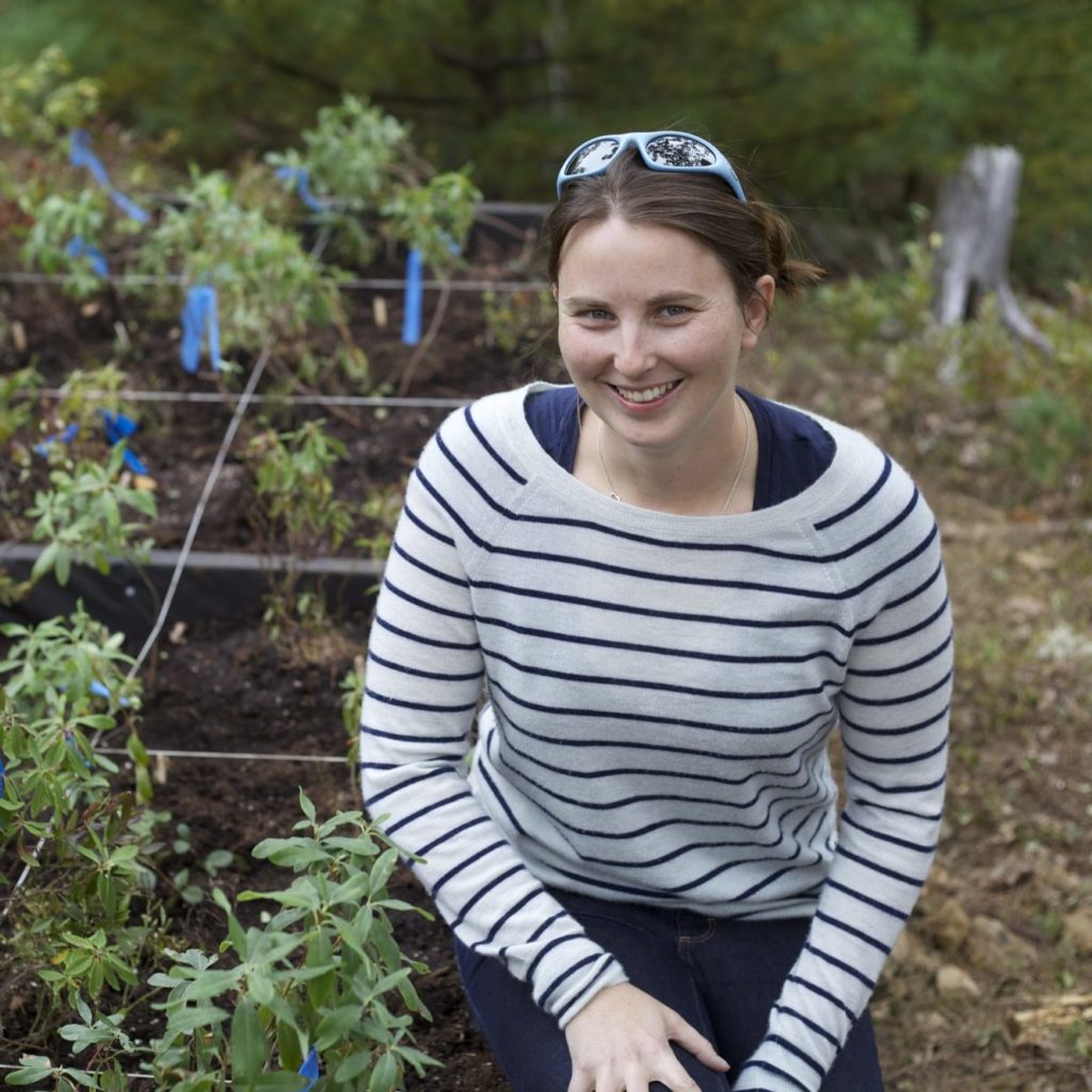 Caitlin in striped shirt next to experimental garden