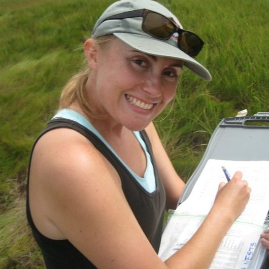 Kate Ruskin holding clipboard with grass in background