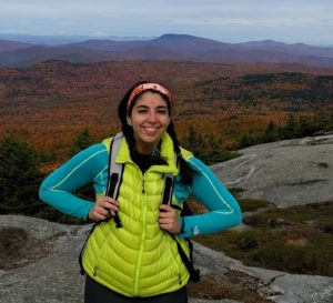 Stephanie in lime green vest with fall foliage in background