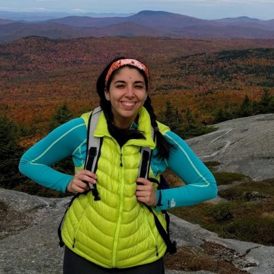 Stephanie in lime green vest with fall foliage in background