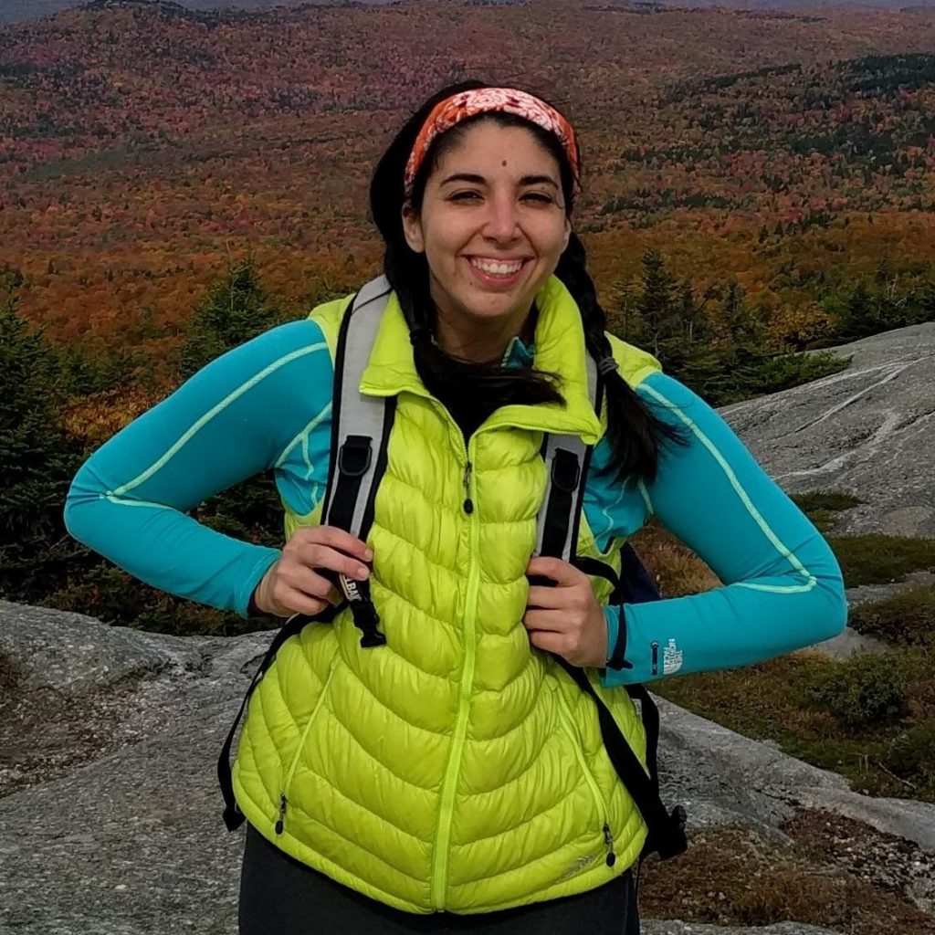 Stephanie in lime green vest with fall foliage in background